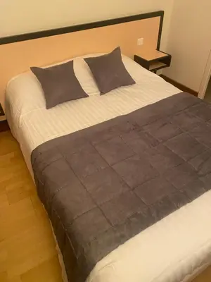 Un ou plusieurs lits dans un hébergement de l'établissement hotel du commerce