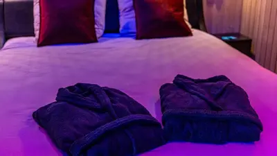 Un ou plusieurs lits dans un hébergement de l'établissement BALNEO - SAUNA - WIFi - LA CLÉ DU DÉSIR