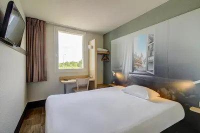 Un ou plusieurs lits dans un hébergement de l'établissement B&B HOTEL BEAUNE Nord