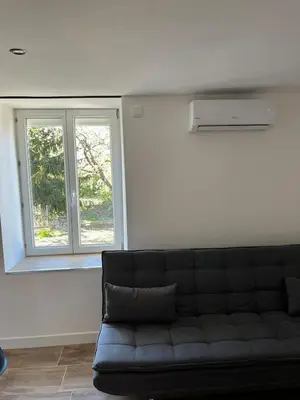 Coin salon dans l'établissement Maison 2 chambres, climatisée avec cour privative