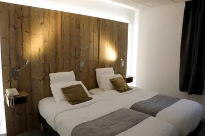 Un ou plusieurs lits dans un hébergement de l'établissement Logis Hotel des Cépages