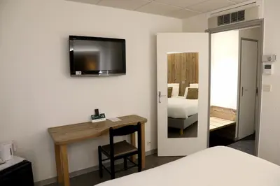 Un ou plusieurs lits dans un hébergement de l'établissement Logis Hotel des Cépages