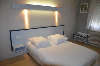 Un ou plusieurs lits dans un hébergement de l'établissement HOTEL DU JURA