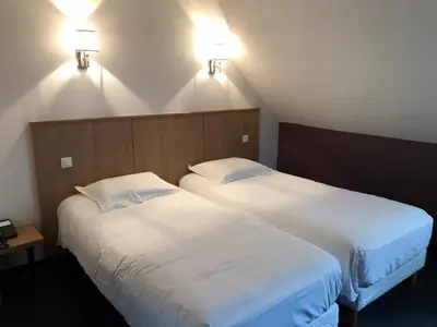 Un ou plusieurs lits dans un hébergement de l'établissement Logis L'Hôtel D'Arc