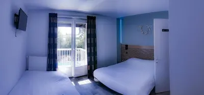 Un ou plusieurs lits dans un hébergement de l'établissement Logis Les Charmilles Chalon-sur-Saône Sud