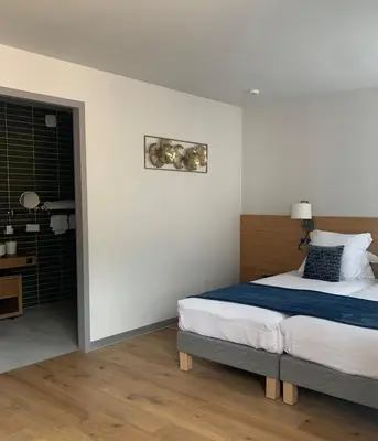 Un ou plusieurs lits dans un hébergement de l'établissement Hôtel L'Ouvrée