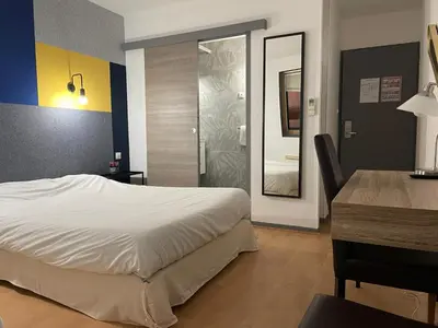 Un ou plusieurs lits dans un hébergement de l'établissement Brit Hotel Dijon Centre Gare